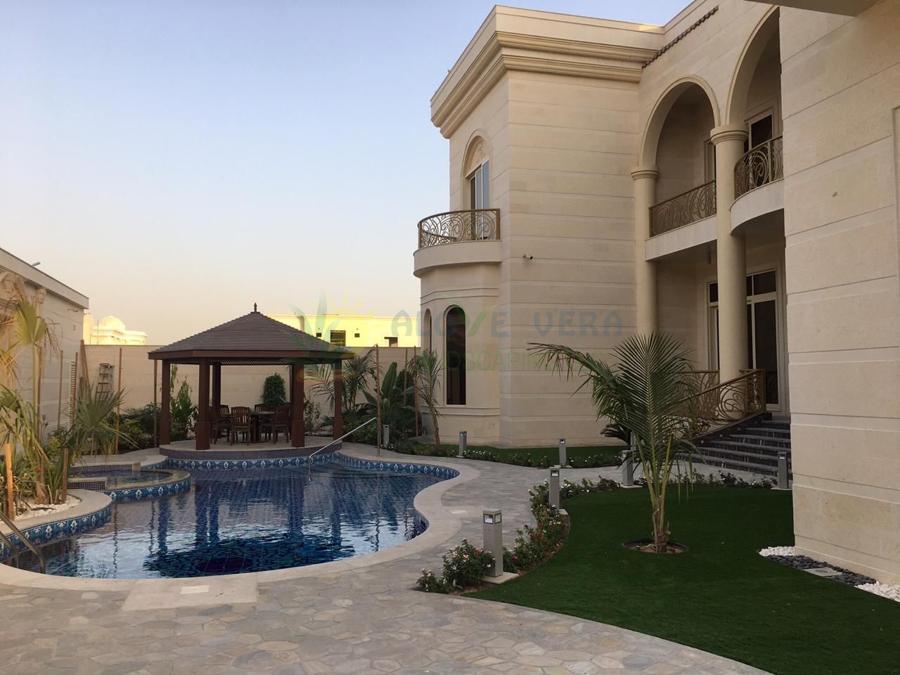 Swimming pool in the backyard with a gazebo besides it