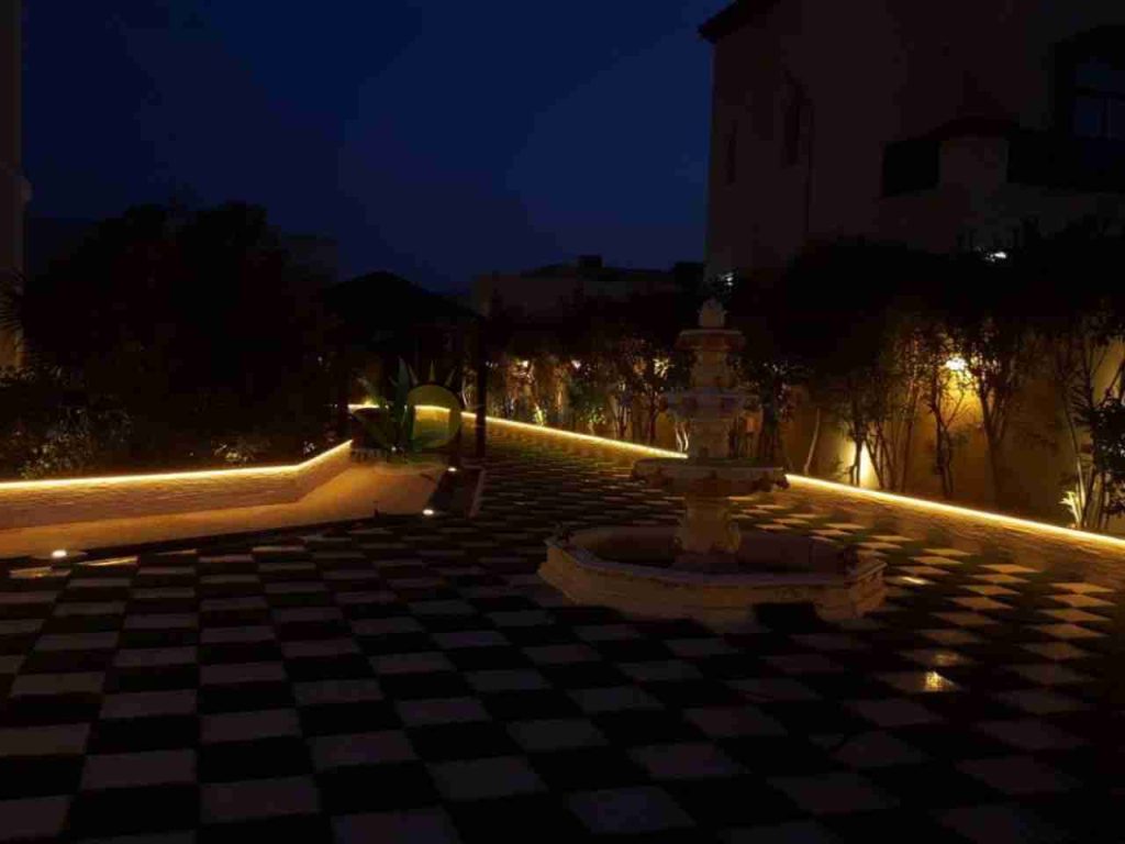 night view of backyard with a fountain