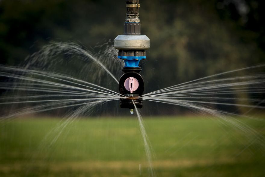 Center pivot system working in a large garden and streams of water spilling out of it