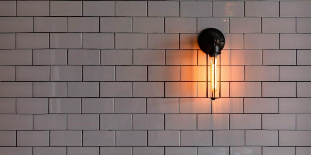 subway tiles and a lamp is lightening in wall